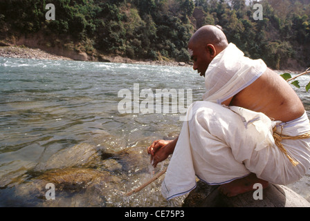 Indian hindu sanyasi washing hands in a river ; india ; asia Stock Photo