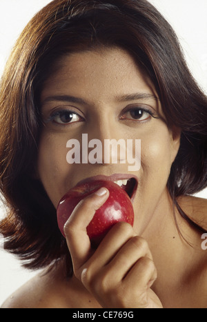 RMM 84779 : South Asian Indian Lady Eating red apple MR#421 Stock Photo