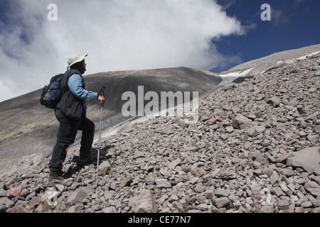 hiker snow field ash outside of crater Mount St Helens Volcano National monument Washington Stock Photo