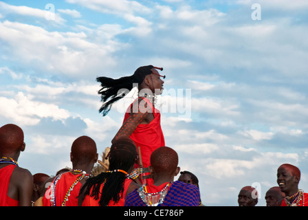 Masai men, doing a jumping dance, wearing traditional dress, in a village in the Masai Mara, Kenya, Africa Stock Photo