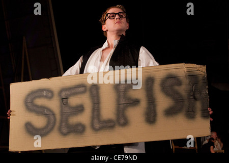 The School for Scandal opens at the Barbican Theatre. Actor holding up 'selfish' sign Stock Photo