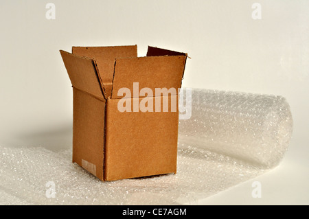 A brown, cardboard box sits on top of plastic bubble wrap. Stock Photo