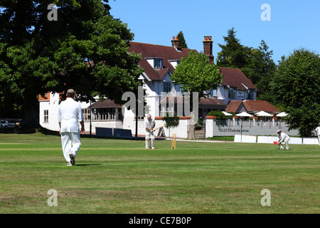 Cricket match in progress , Hand and Sceptre hotel in background , Southborough Common , near Tunbridge Wells , Kent , England Stock Photo