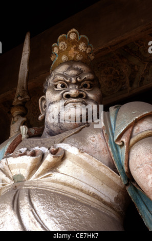 An old terracotta sculpture depicting a temple guardian in Shuanglin Si Buddhist temple date to the Ming and Qing dynasties near the city of Ping Yao officially Pingyao Ancient City in central Shanxi, China Stock Photo