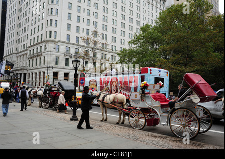 View towards West 59th Street Plaza Hotel, sight-seeing tour bus passing three horse-drawn carriages, Grand Army Plaza, New York Stock Photo