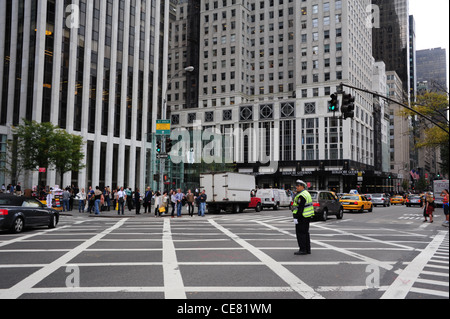 View to Apple Store white skyscrapers, cars, people, NYPD policeman directing traffic, 5th Avenue West 59th Street, New York Stock Photo