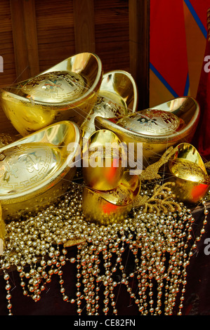 Gold Yuanbao Ingots on a table, indicating wealth, luck and fortune for Chinese New Year Stock Photo