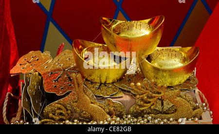 Gold Yuanbao Ingots on a table, indicating wealth, luck and fortune for Chinese New Yea Stock Photo