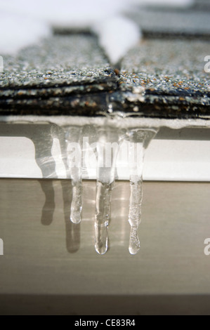 Icicles on roof melting. Stock Photo