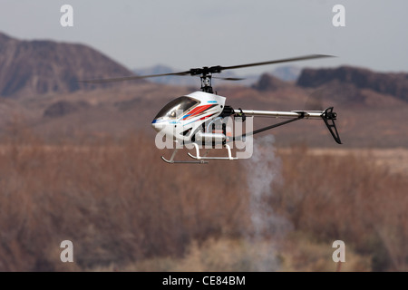 RC helicopter in flight in front of mountains Stock Photo