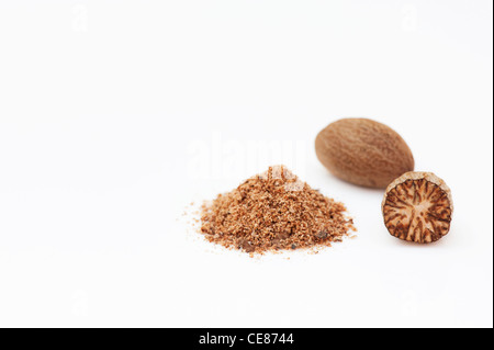 Myristica fragrans. Nutmeg and ground nutmeg on white background Stock Photo