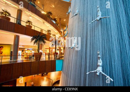 Dubai, waterfall and sculptures of diving men inside Dubai Mall Stock Photo