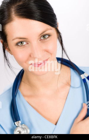 Young brunette woman doctor nurse in blue medical gown holds out her ...