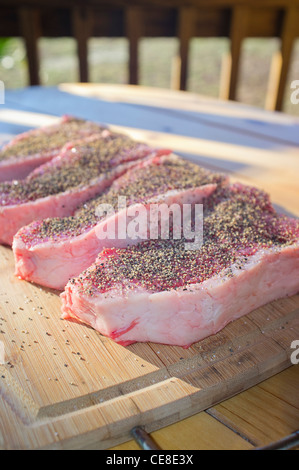 Beef strip loin steaks seasoned with salt and black pepper Stock Photo