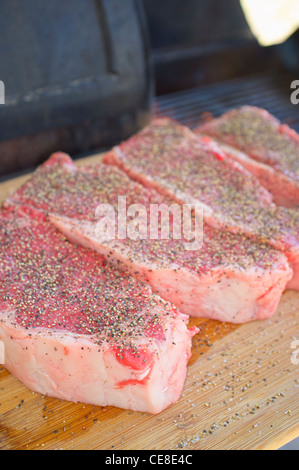 Seasoned New York strip steaks ready to grill Stock Photo