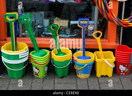 multicolor multicolored plastic bucket spade toy childrens buckets spades holiday summer sale display outside shop path Stock Photo