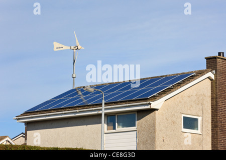 Windsave micro wind turbine and solar panels on a domestic eco home house roof for alternative energy. UK Stock Photo