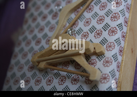 Dolls house coat hangers on a bed. Stock Photo