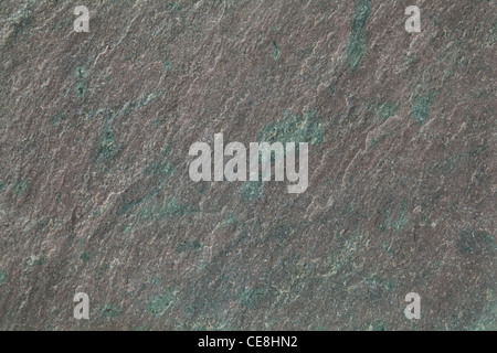 flat, gray, fine-grained, foliated slate rock with purple tint and green spots and veins Stock Photo