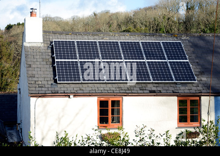 Solar panels fitted to the roof of an old cottage Stock Photo