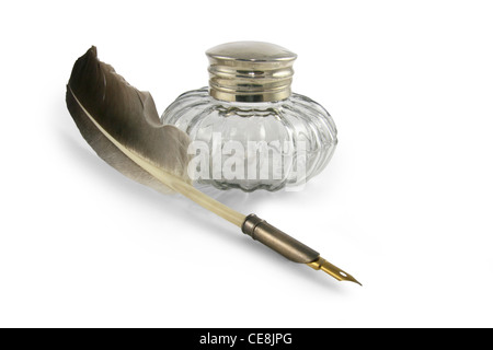 Feather quill pen in a circa 1890s to 1940s style glass inkwell. Stock Photo