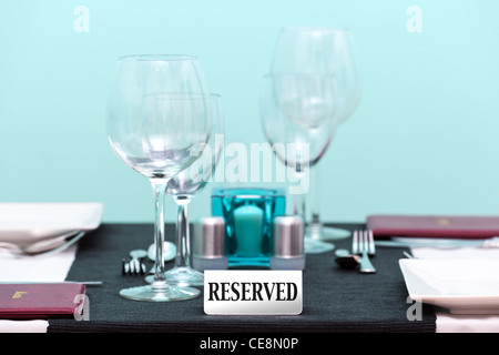Photo of the reserved sign on a restaurant table setting. Focus is on the sign with a very shallow depth of field. Stock Photo