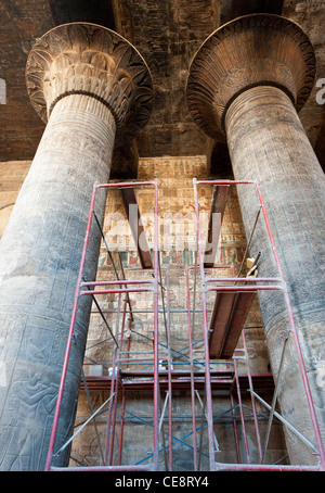 Columns in the ancient egyptian temple of Khnum at Esna with hieroglyphic carvings and scaffolding for restorations Stock Photo