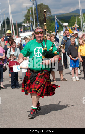 Men in kilts and funny hats and sunglasses play the bagpipes at the homecoming event on the caledonian canal Stock Photo