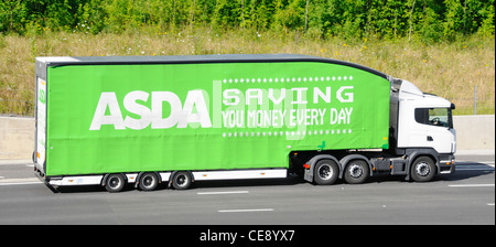 Asda supply chain supermarket store hgv delivery lorry truck and articulated trailer with large advertising slogan driving along UK motorway Stock Photo