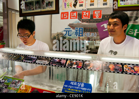 Stall selling traditional Korean sweets with two young men talking to customers, Insadong, Jongno-Gu, Seoul Stock Photo