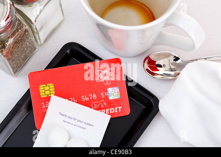 Photo of a credit card placed on a tray to pay for a restaurant bill.