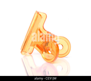 Orange colored office paper clip on white background Stock Photo