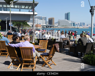dh  TSIM SHA TSUI EAST HONG KONG People relaxing Starbucks kowloon cafe Victoria harbour waterfront promenade china couple in outdoor cafes Stock Photo