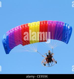 Colorful paraglider on blue bright sky Stock Photo