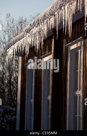 Icicles hanging from house eaves , Finland Stock Photo