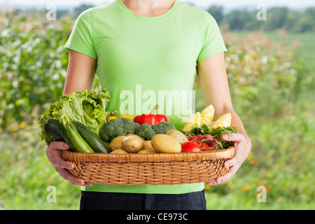 USA, Illinois, Metamora, midsection of woman holding freshly harvested vegetables Stock Photo