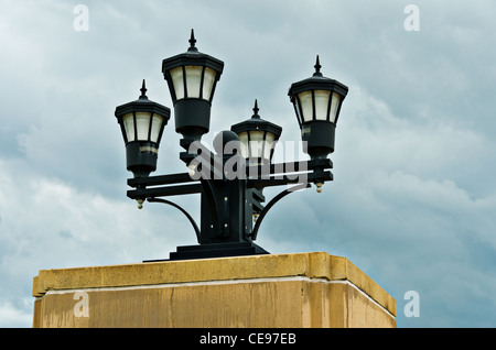 A four poled street light with dark moody clouds in the background Stock Photo