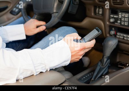 USA, Illinois, Metamora, driver's hands holding cell phone Stock Photo