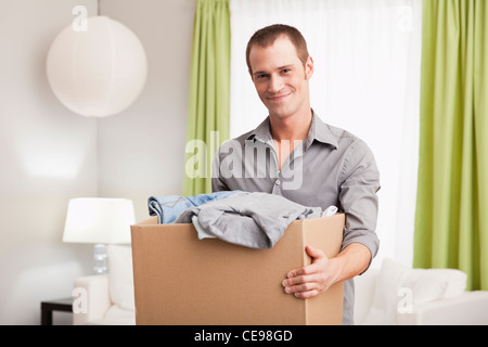USA, Illinois, Metamora, Portrait of smiling man carrying cardboard box with clothes Stock Photo