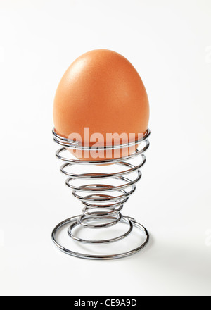 Brown egg in modern spiral metal egg cup Stock Photo