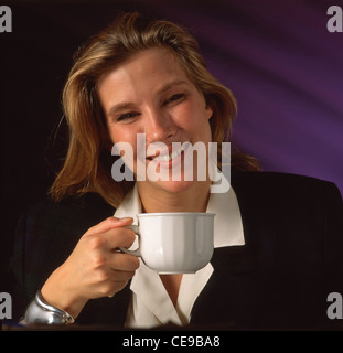 Young businesswoman drinking cup of tea, Berkshire, England, United Kingdom Stock Photo