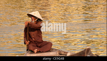 Vietnamese boatman in a small boat on the Thu Bon River, Hoi An, Viet Nam Stock Photo