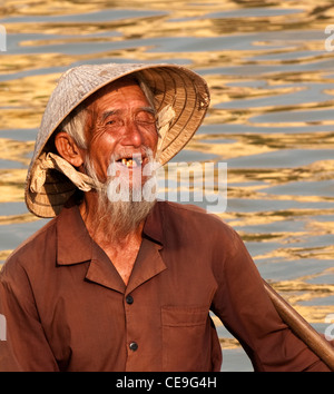Vietnamese boatman in a small boat on the Thu Bon River, Hoi An, Viet Nam Stock Photo