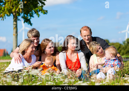 Family and multi-generation - mother, father, children and grandmother having fun on meadow in summer Stock Photo