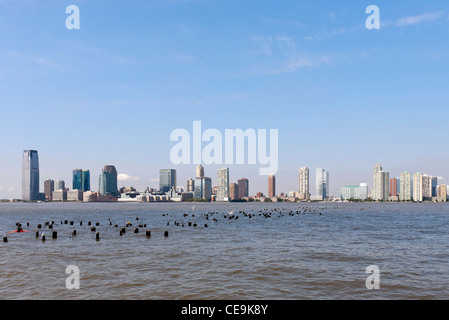 A view of the Jersey City, New Jersey skyline from across the Hudson River and the New York City Pier 25. Stock Photo