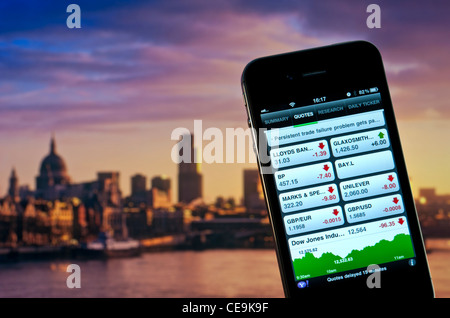 FTSE 100 iPhone  screen displaying 2012 poor trading day on FTSE 100 London Stock Markets with City of London and River Thames in background Stock Photo