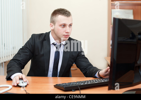 Portrait of a smart young businessman working on computer at office Stock Photo