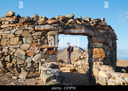 Male hiker on mountain footpath on the undeveloped west coast of Fuerteventura, Canary Islands, Spain Stock Photo