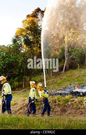 Fireman training with hosepipe while putting out-fire during training exercise. Stock Photo