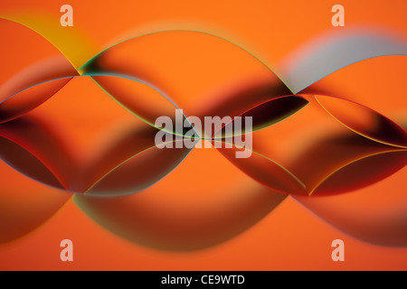 background image of colorful origami pattern made of curved sheets of paper, on orange background, with mirror reflexion Stock Photo